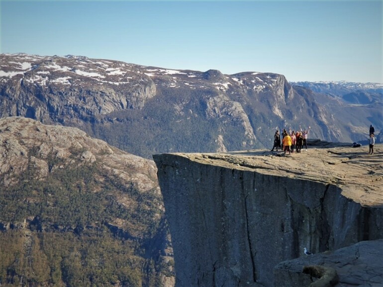 Maisemakuva, kalliokieleke, jossa seisomassa ihmisiä.