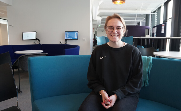 Student Lara sitting on a sofa.