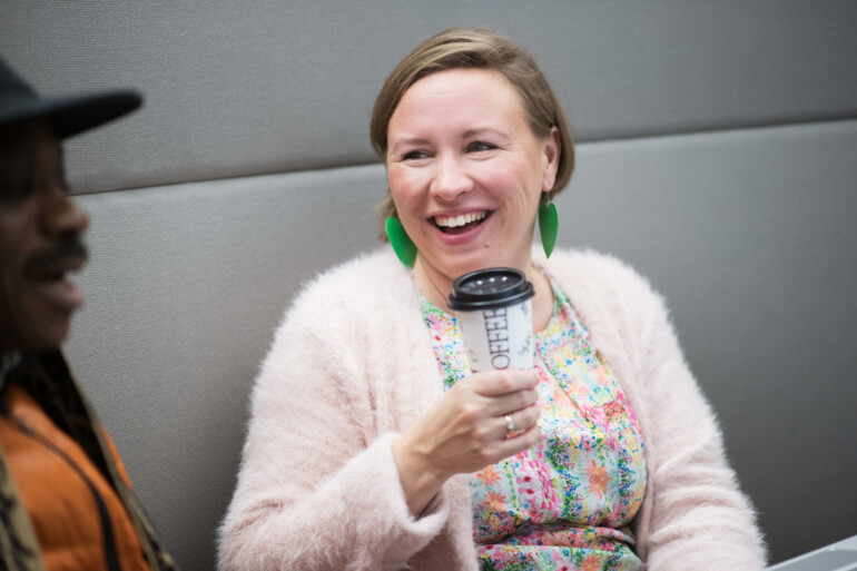 Woman and a man talking, woman holding a coffee cup.