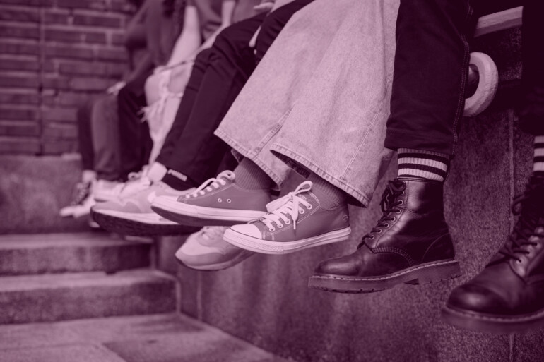 Nuoret istuvat, kuvassa nuorten kenkiä ja jalkoja.