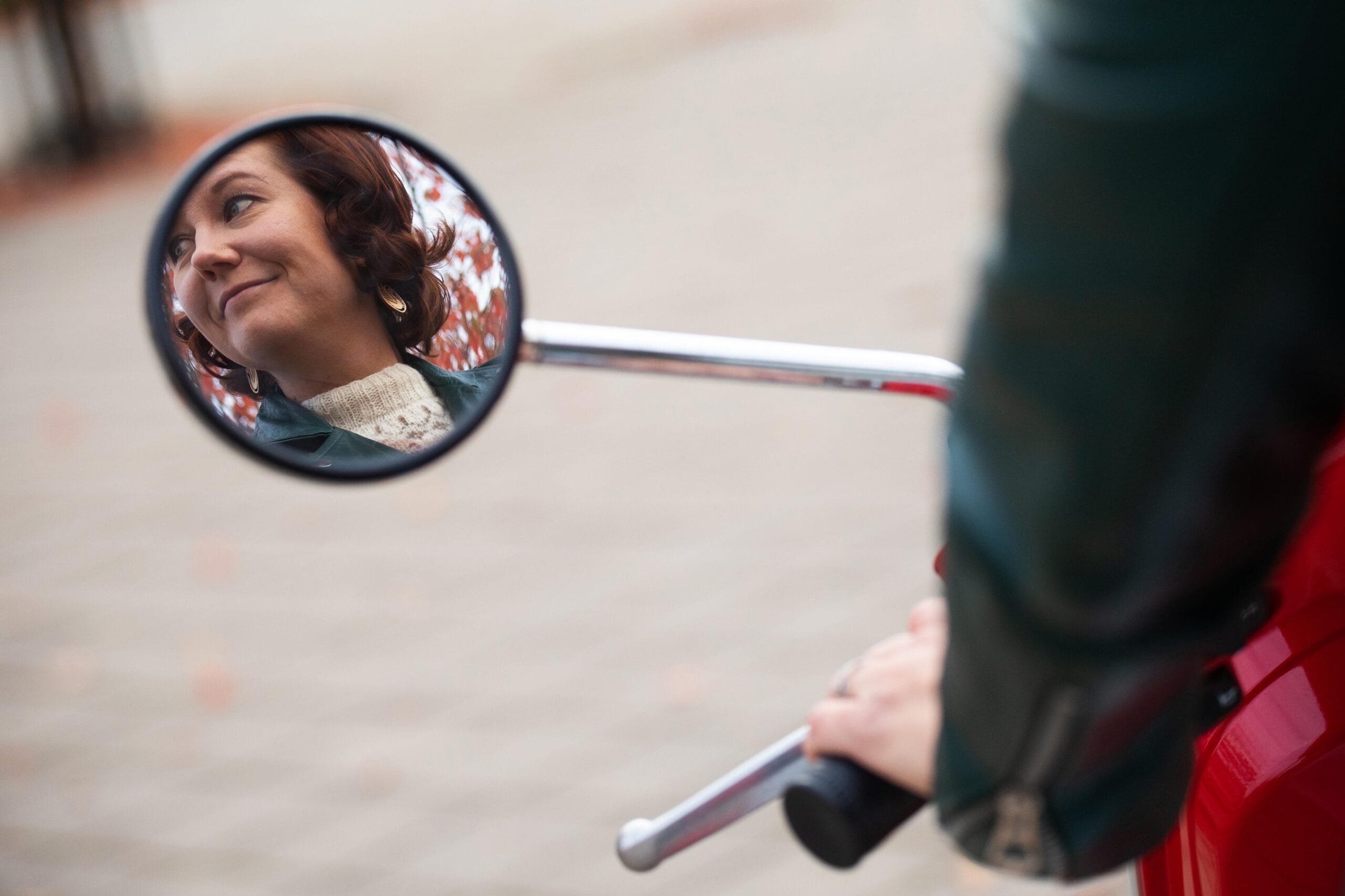 Piritta Jalonen katsoo mopon peruutuspeilistä.