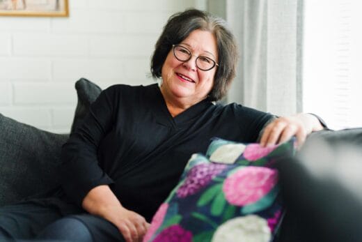 Tuija Oivo istuu sohvalla.