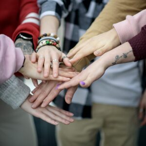 Kädet ovat pinossa yhteistyön merkiksi.