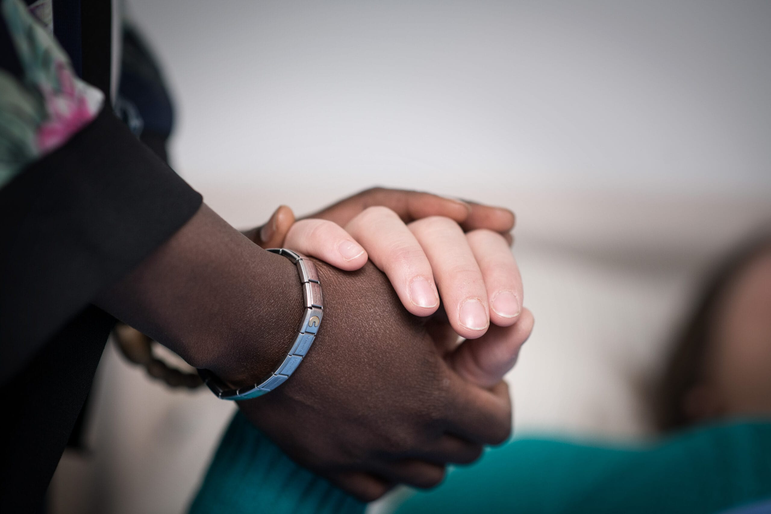 Nainen pitää kiinni toisen naisen kädestä.