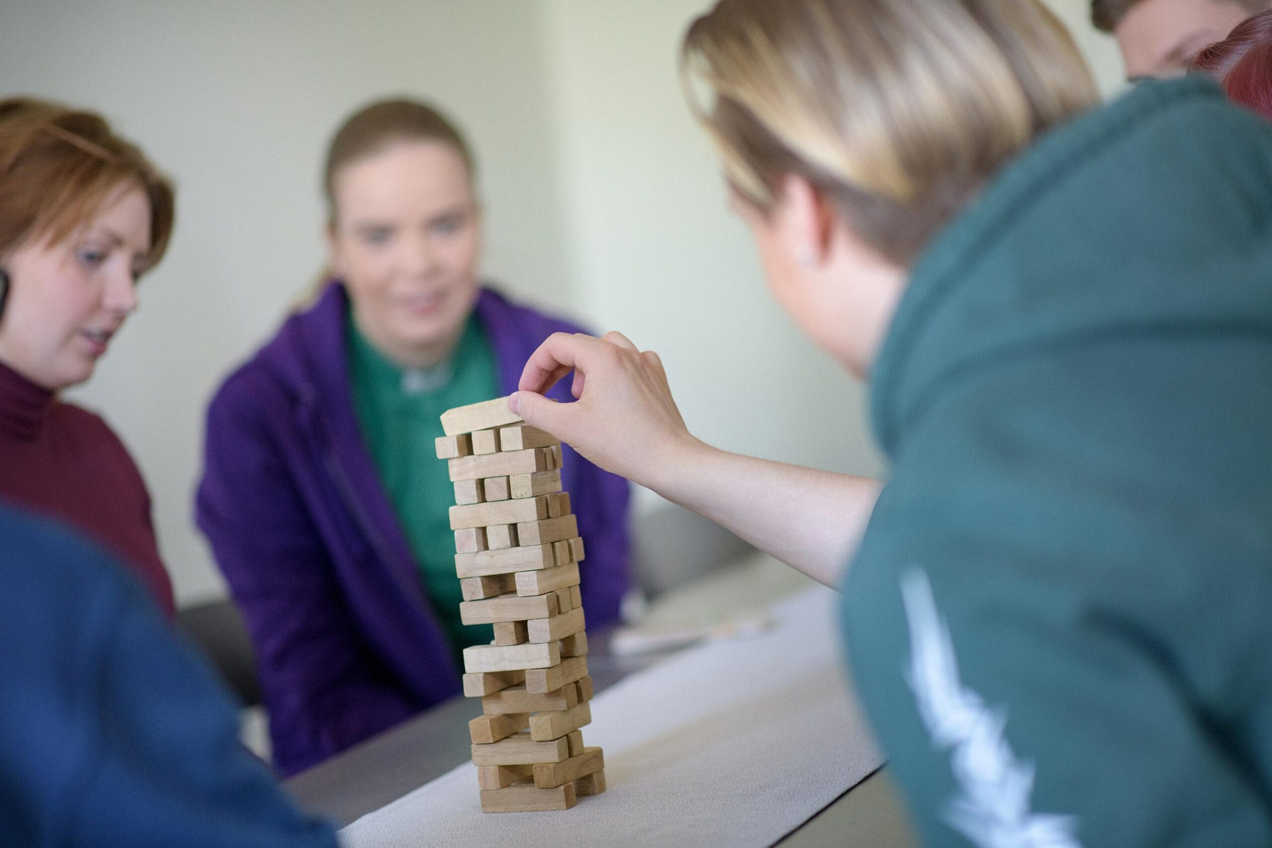 Opiskelijoita rakentamassa palikoilla tornia, kuvituskuva.