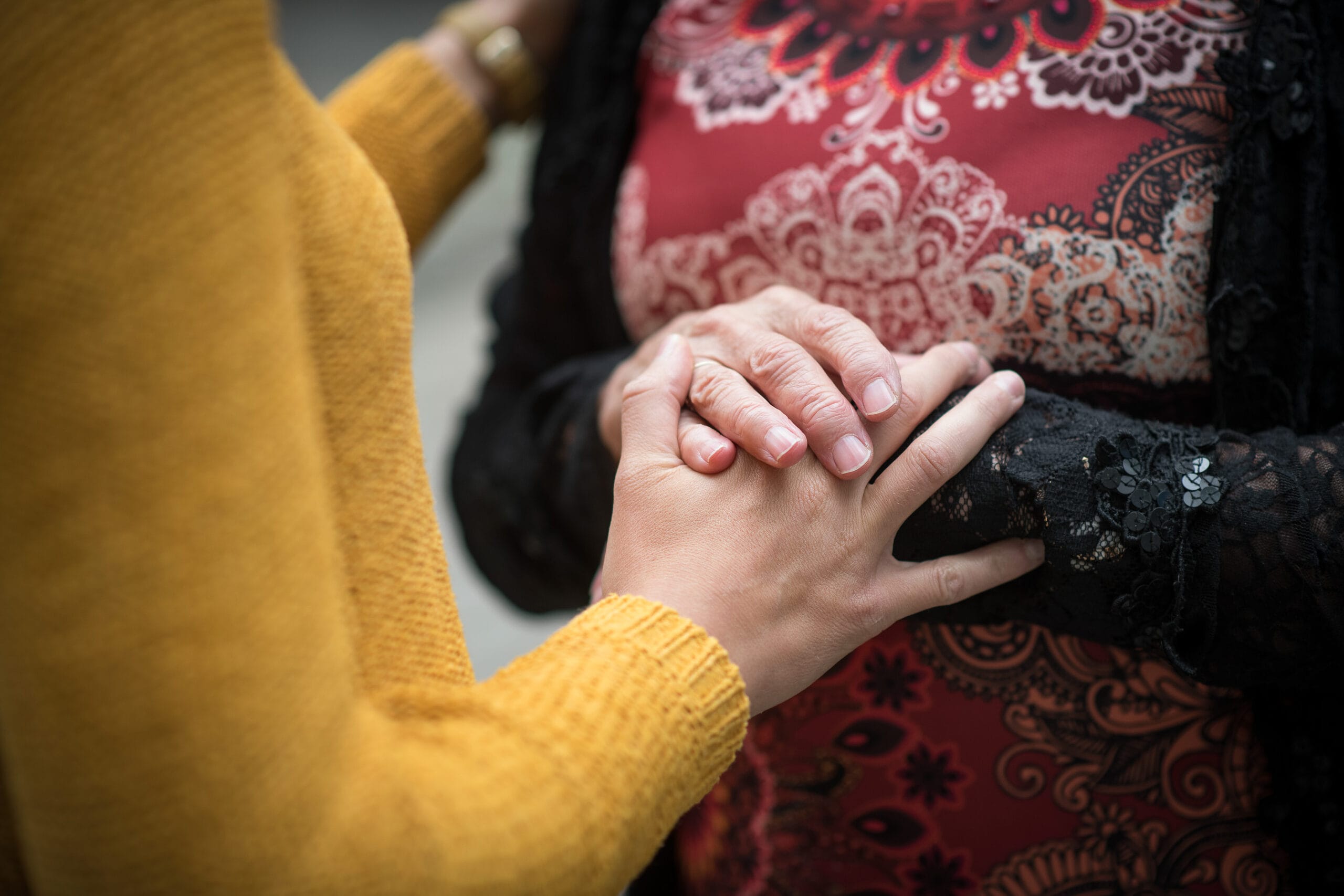 Kaksi henkilöä, jotka pitävät käsiään yhdessä.