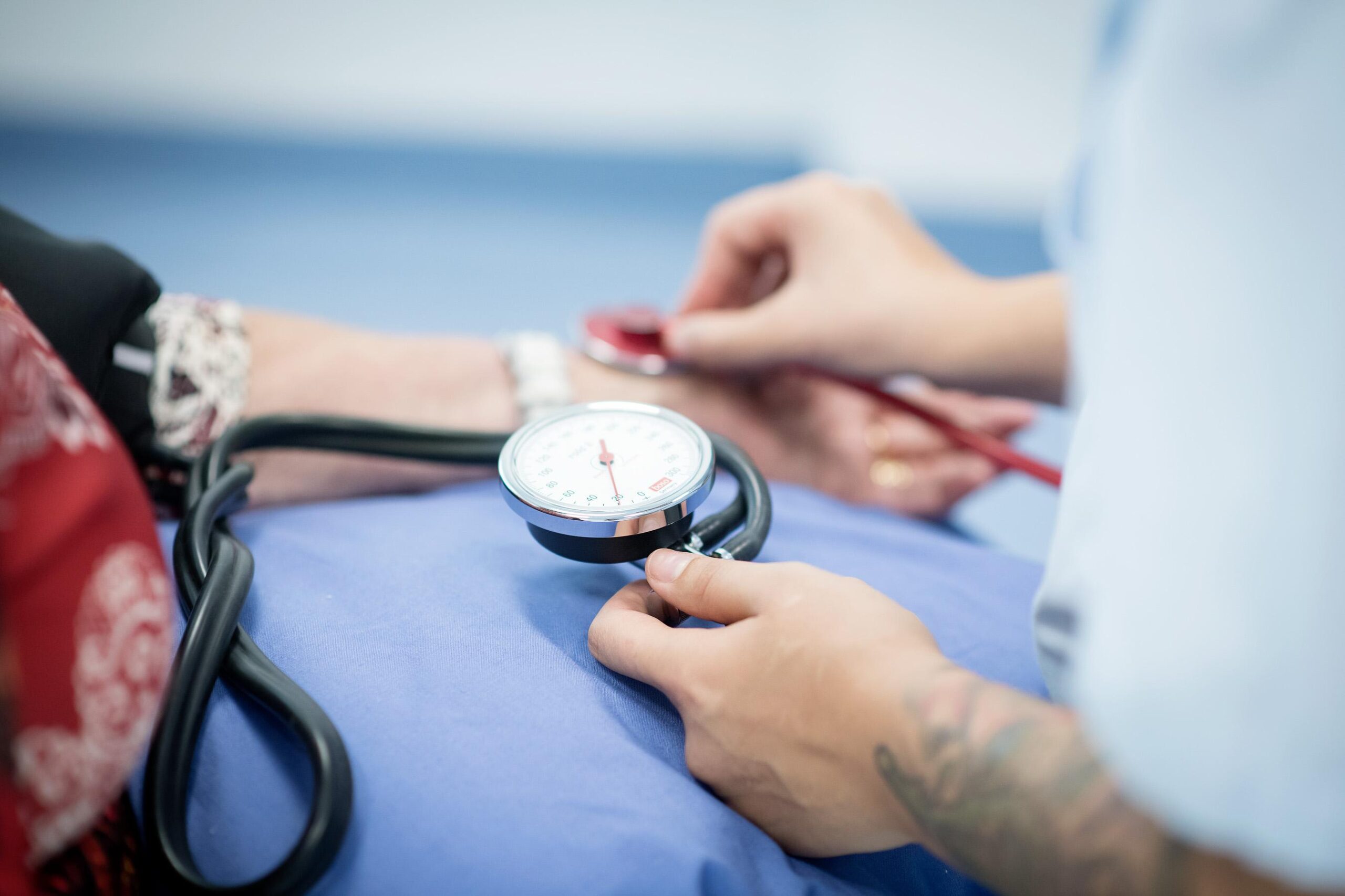 Sairaanhoitaja mittaa verenpainetta potilaan kädestä.