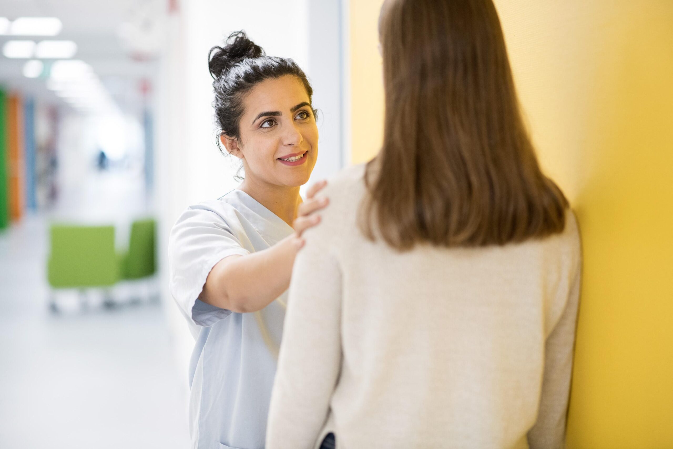 Sairaanhoitaja keskustelee nuoren asiakkaan kanssa.