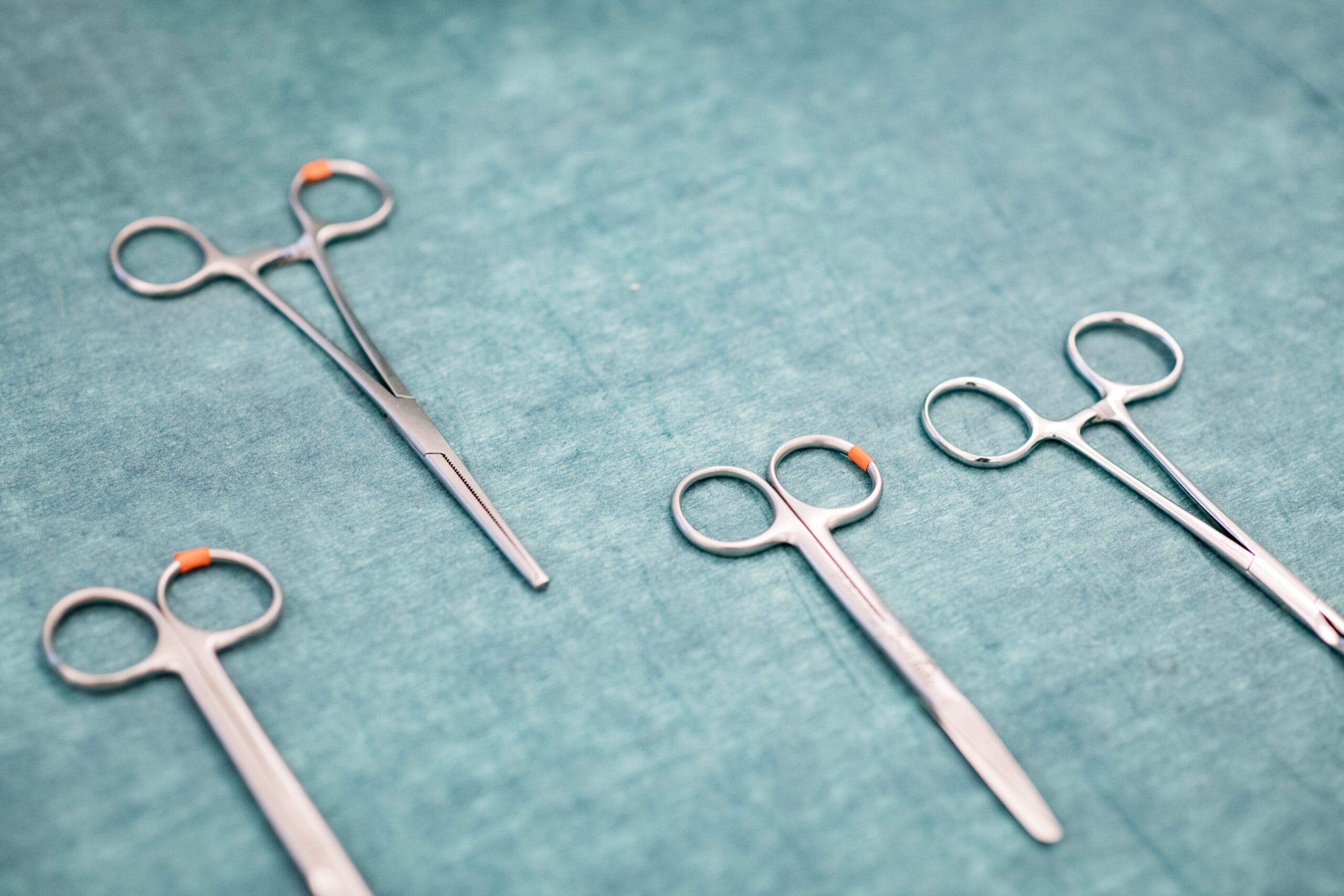 saksia vihreällä alustallahoitaja tutkii potilaan hengitystä.hoitaja katsoo vastapäätään olevaa henkilöä ja pitää kättä hänen hartiallaan.seisova henkilö pitää sängyssä makaavaa kädestähoitajaa tekee tutkimusta potilaalle.hoitaja sitoo sängyssä makaavan potilaan kättä.