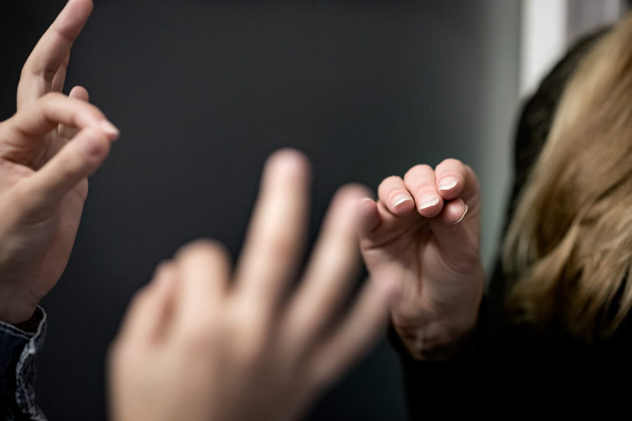 Kuvassa on käsiä kuvastamassa tulkkaustilannetta.