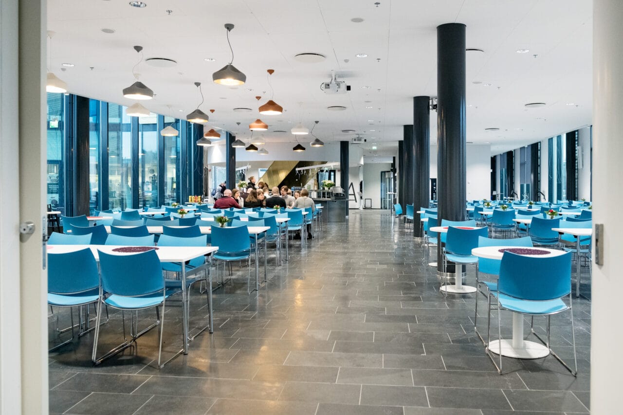 Avara tila, jossa sinisiä tuoleja.