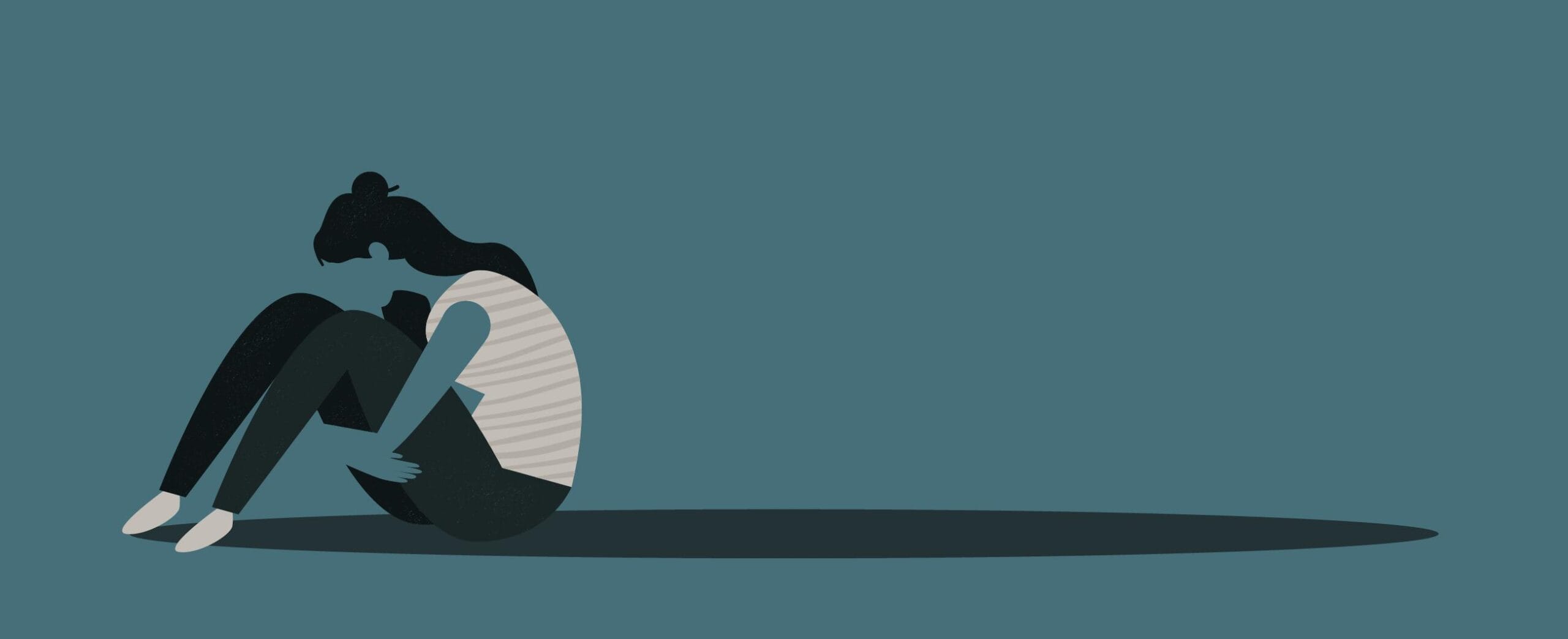 jossa hahmo istuu maassa pitäen käsillään reisistä kiinni.