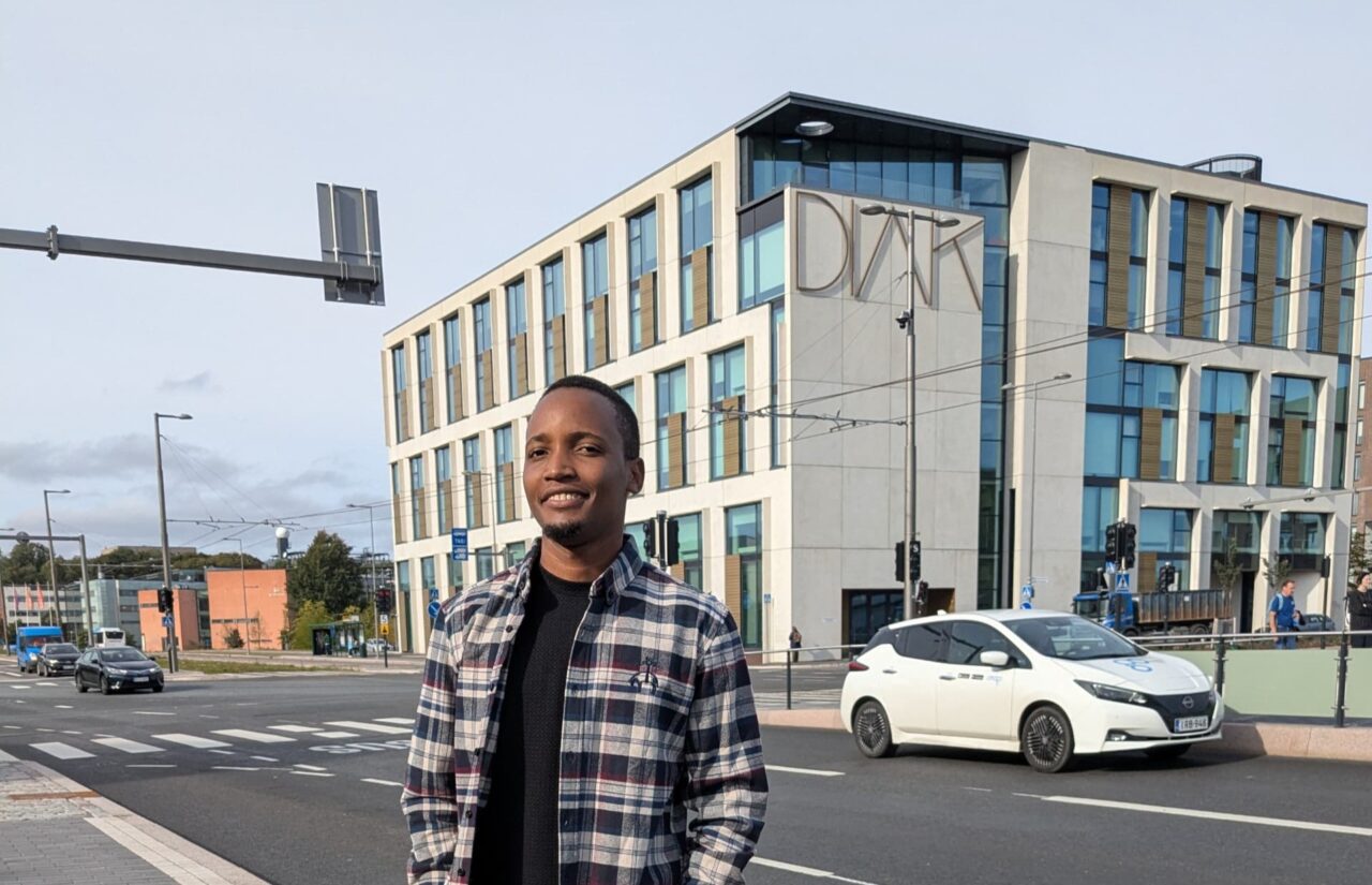 Edwin Renatus Mwacha Diakin Helsingin-kampuksen edessä.Logo: Funded by the European Union.