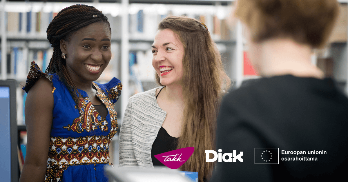 Tummaihoinen ja valkoihoinen tyttö hymyilevät rinnatusten.