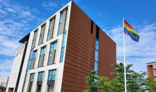 Diak campus in Helsinki and a flag pole with a rainbow flag.
