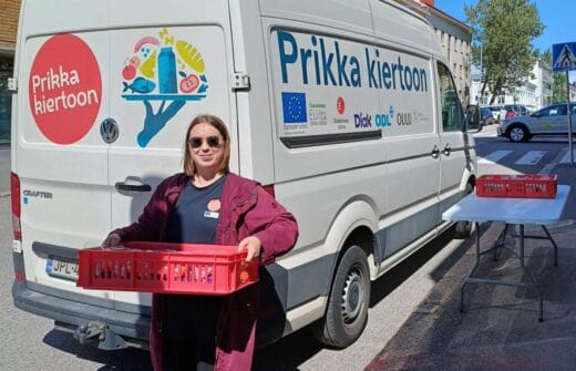 Nainen pakettiauton edessä kantaa ruokalaatikkoa.Prikka kiertoon -pakettiauto.Prikka kiertoon -projektikoordinaattori Anna (ODL).Prikka-tarjotin ja hankelogot.Hankelogot rivissä.