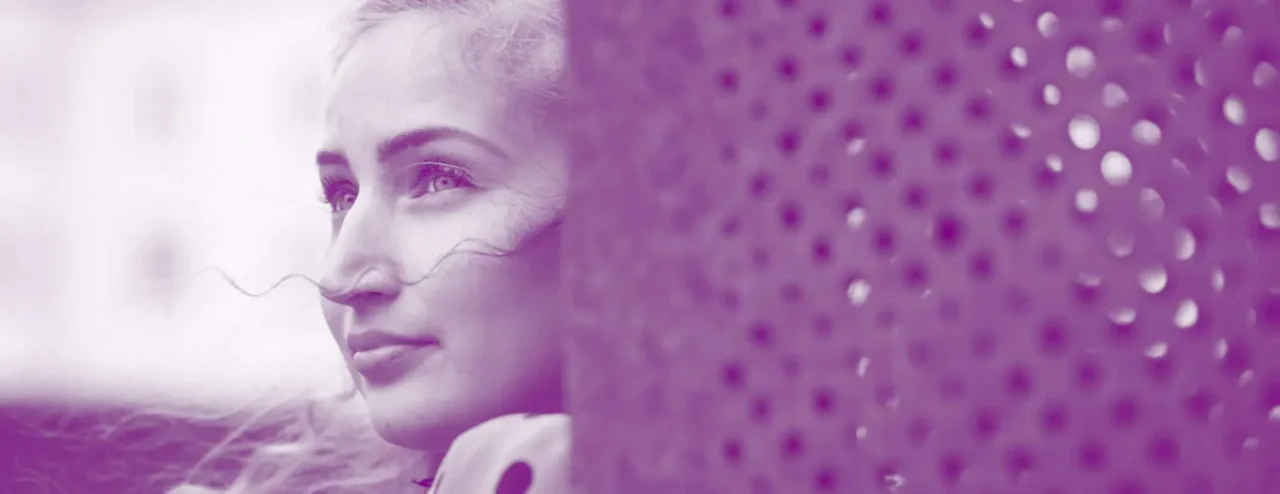 Romaninainen katsoo vasemmalle, etualalla ristikkoseinää.