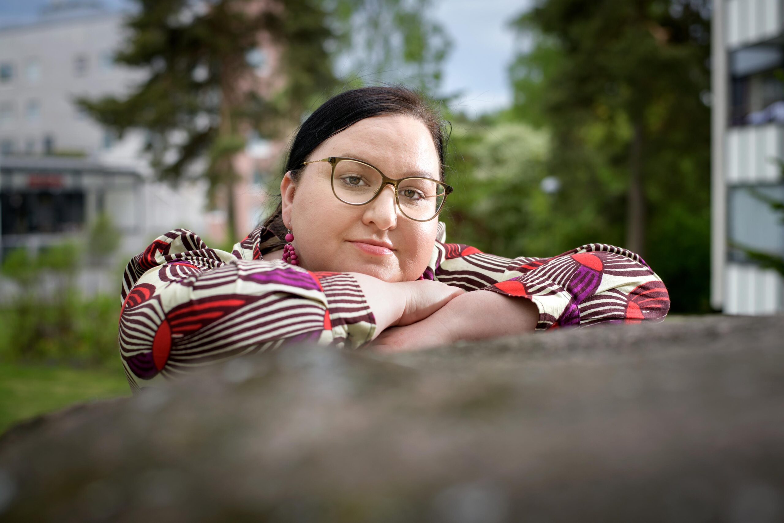 Tadeja Munyui katsoo kiven takaa kameraan.