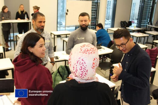 Koulutettavien ryhmä (5 henkilöä) juttelemassa keskenään.Lehtori Katja Päällysaho kirjoitti ylös ryhmän säännöt.Kaksi naista