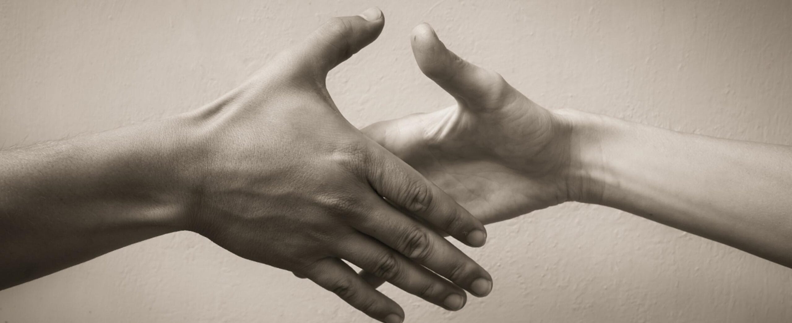 Valokuva. jossa kaksi ihmiskättä kohtaa kättelyssä.