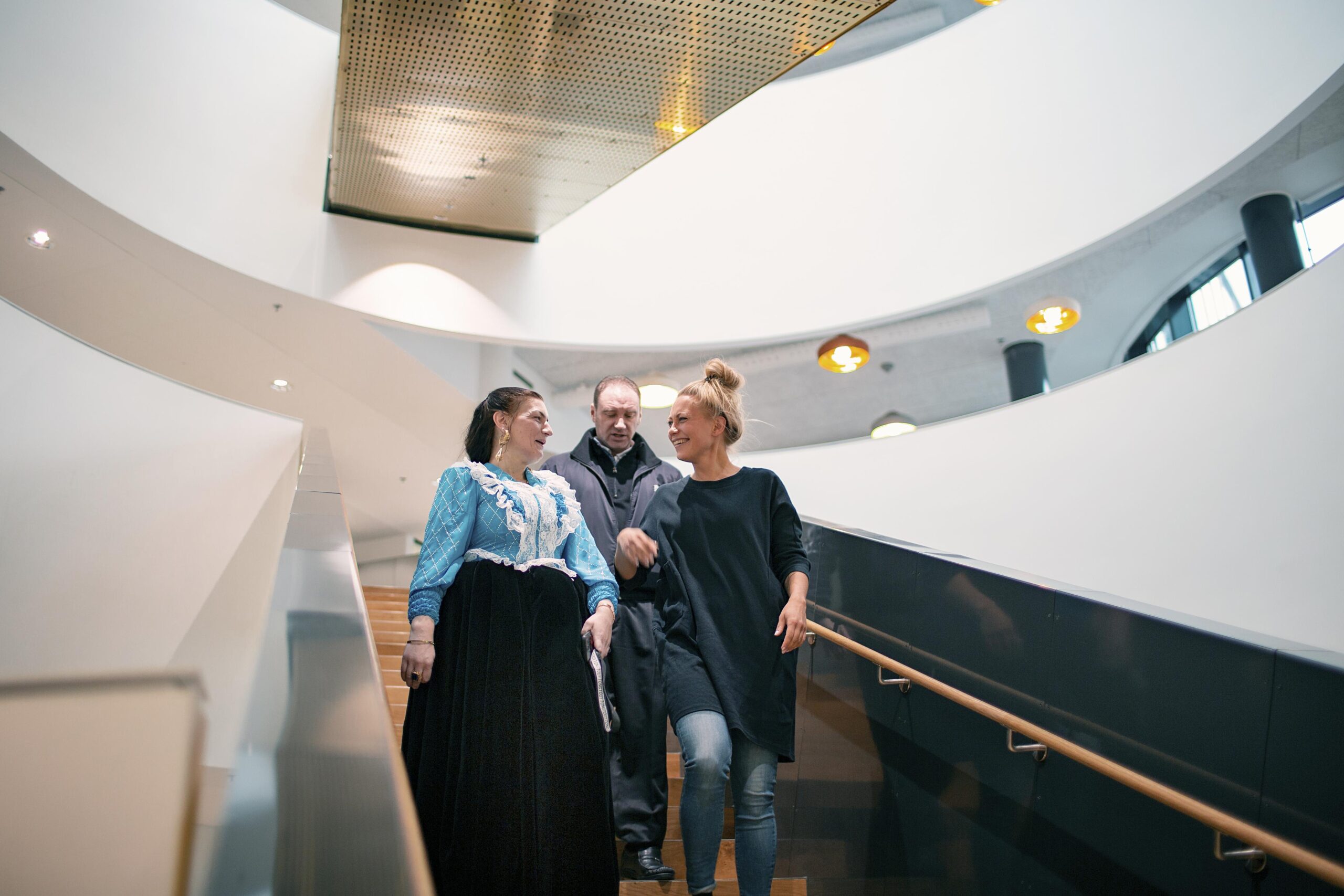 kolme henkilöä tulossa portaita alas.kitaran- ja viulunsoittaja sekä teksti "Tohtorikoulutettavaksi otetaan todella pieni määrä ihmisiä vuosittain".