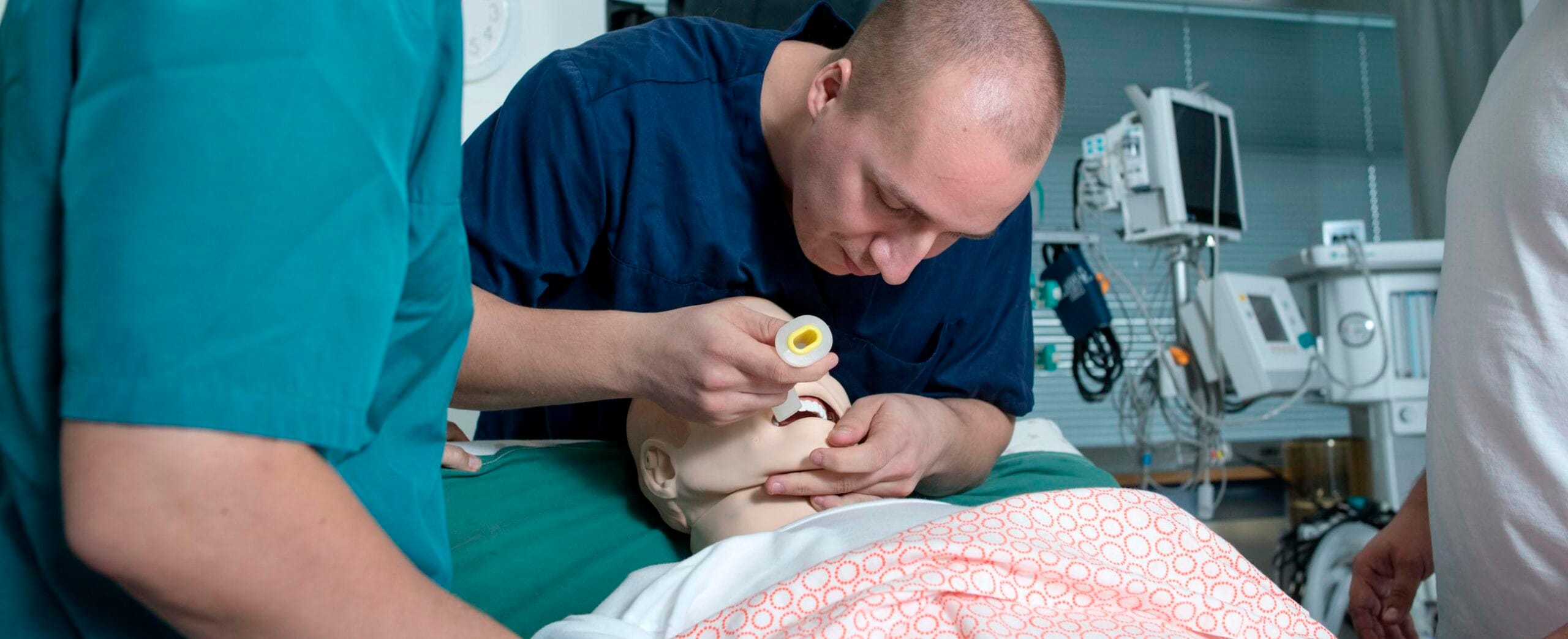 Kristiina Rosqvist.opettaja seuraa simulaatio-opetusta.henkilöt hoitamassa potilasta esittävää nukkea.henkilöt hoitamassa potilasta esittävää nukkea.