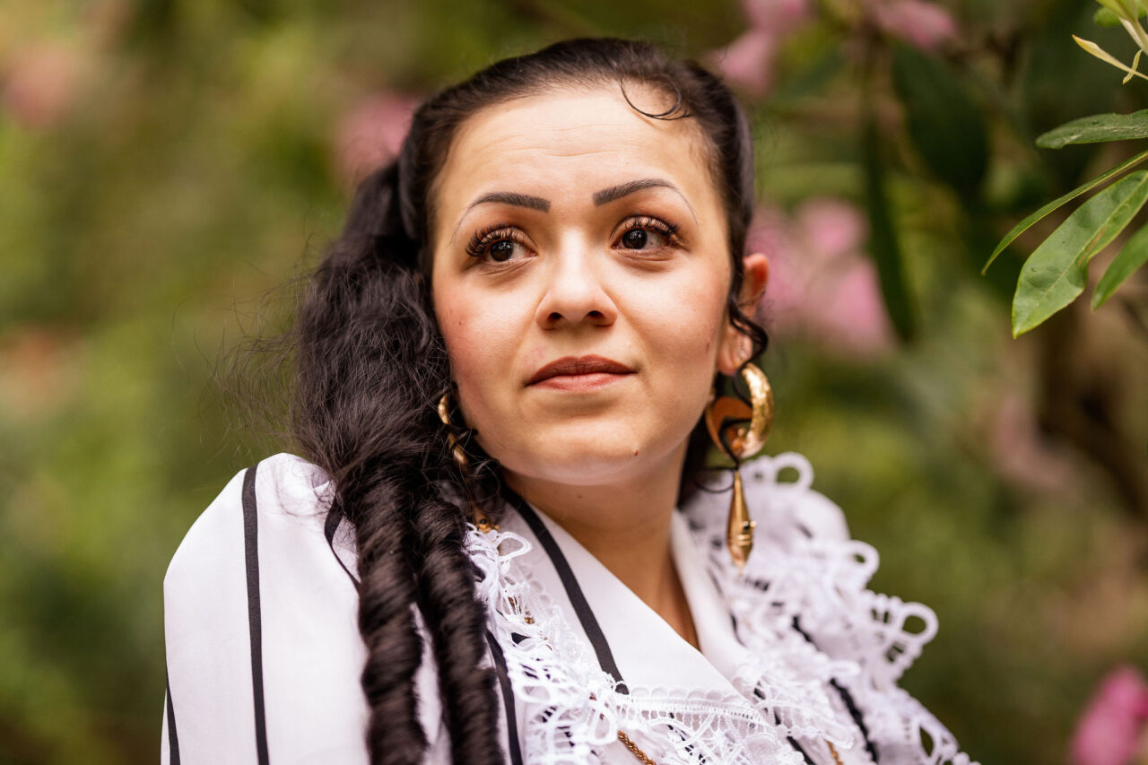 Henkilö katsoo haaveillen yläviistoon vehreällä pihalla.