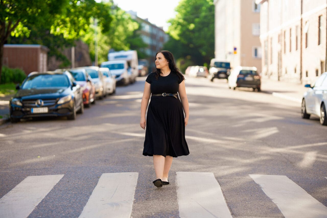 Tyttö kävelee keskellä katua kaupungissa.