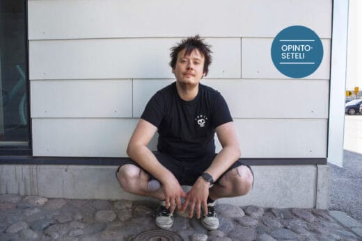 Nuori mies on kyykkyasennossa valkean seinän edustalla. OIpintosetelin logo taustalla myös.